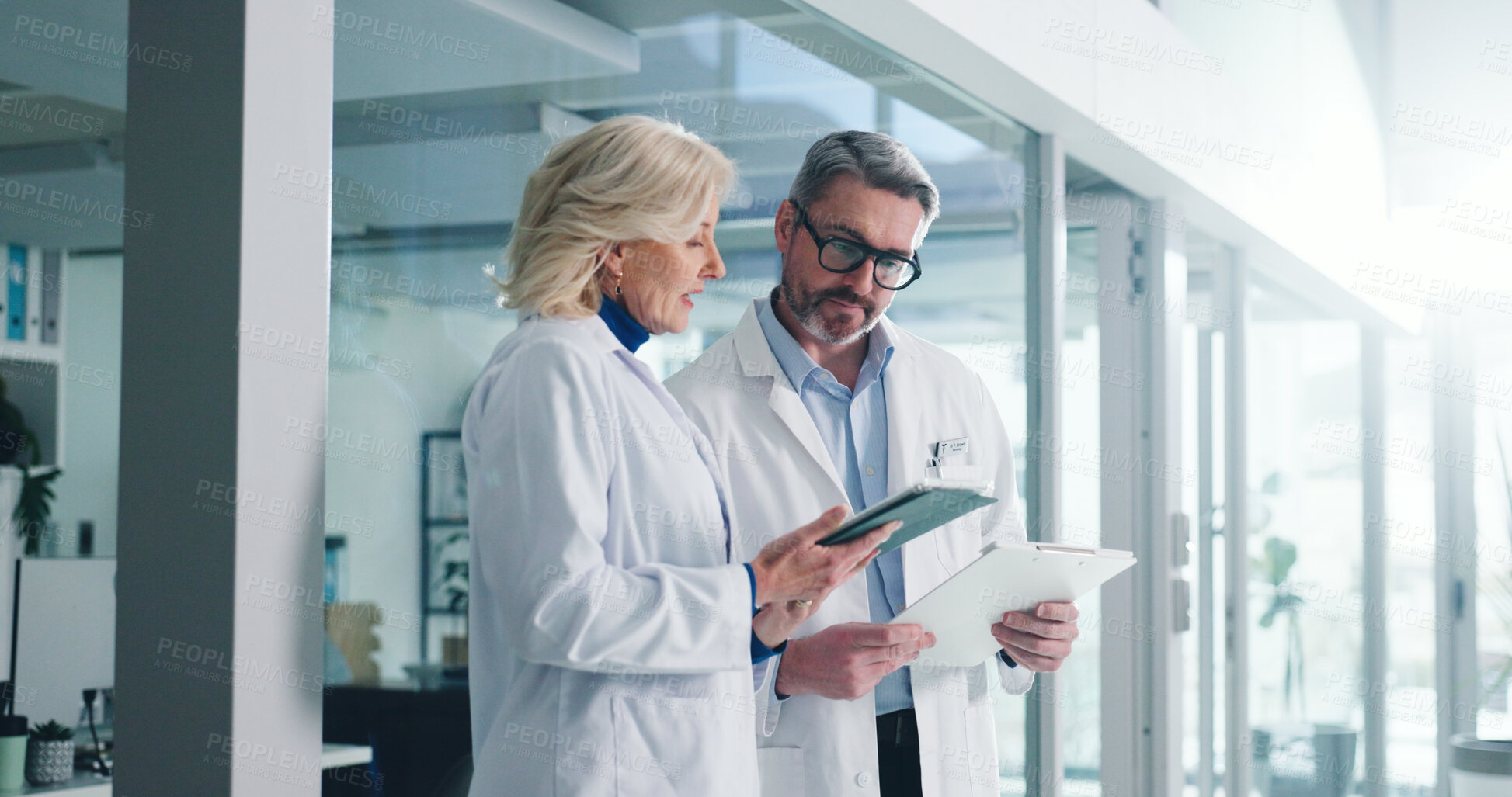 Buy stock photo Teamwork, tablet and reading with doctors in hospital for healthcare report, research and planning. Medical case review, clinical guidelines and telehealth app with mature people for diagnosis