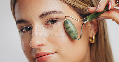 Buy stock photo Jade roller, skincare and portrait of woman in studio for detox, smooth skin and grooming. Spa, dermatology and person with beauty tools for facial massage, anti aging and glow on white background