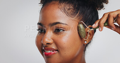 Buy stock photo Beauty, jade roller and woman with smile in studio for skin benefits, lymphatic drainage or glow. Skincare, african person and cosmetics tool on white background for anti aging or puffiness reduction