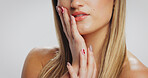Hands, lipstick and woman in studio with white background, skincare and nail art for aesthetic. Beauty, dermatology and model in manicure with facial care, cosmetics and make up for confidence.