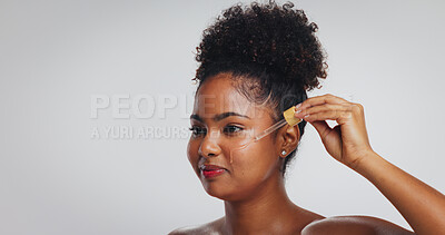 Buy stock photo Beauty, skincare and woman with serum in studio for hydration, hyaluronic acid or skin benefits. Dropper, black person or apply vitamin c on white background for face elasticity, glow or mockup space