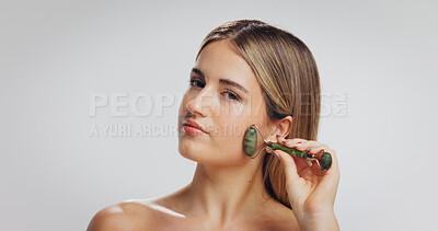 Buy stock photo Beauty portrait, woman and jade roller in studio for lymphatic drainage, skin glow and benefits. Mockup space, person and cosmetics tool on white background for face radiance and improve circulation
