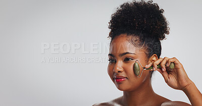 Buy stock photo Skincare, jade roller and woman with thinking in studio for anti aging benefits, radiance and glow. Natural beauty, mockup space and african person with cosmetics tool on white background for routine