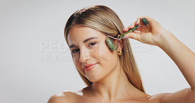 Buy stock photo Roller, skincare and portrait of woman on a white background for wellness, facial massage or beauty. Mockup, studio space and person with jade stone for lymphatic drainage, anti aging and dermatology