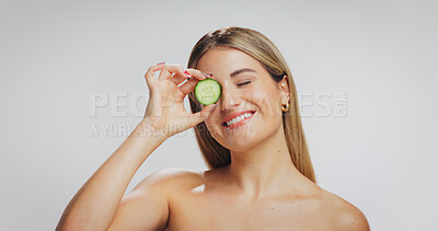 Buy stock photo Skincare, happy and woman with cucumber in studio with beauty, natural or facial treatment. Smile, cosmetic and female person with fruit for dermatology routine with hydration by white background.