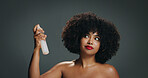 African woman, natural hair and spray in studio for texture, haircare and cosmetics. Red lipstick, beauty and afro girl on gray background with shine, moisture mist and healthy growth product