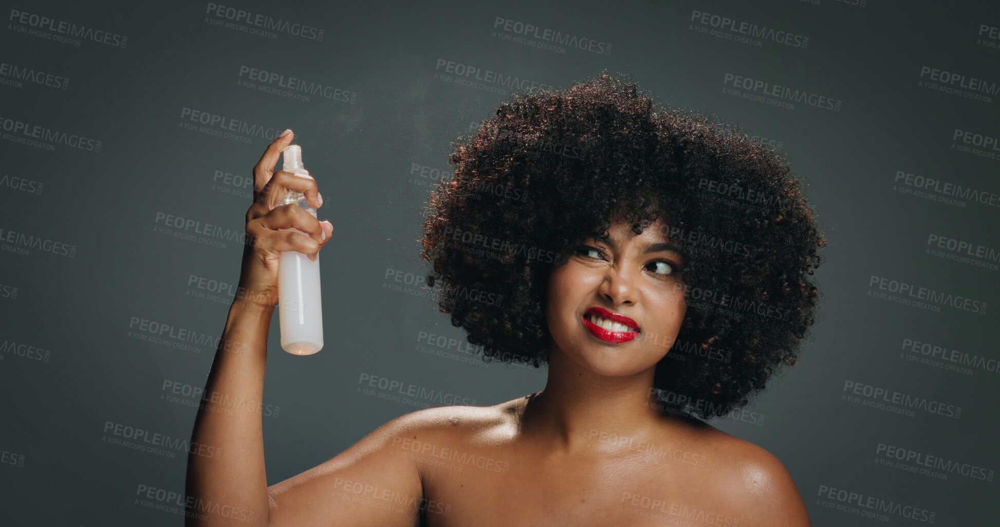 Buy stock photo Woman, natural hair and spray in studio for texture, haircare and cosmetics. Red lipstick, beauty and african girl on gray background with afro shine, moisture mist and healthy growth product