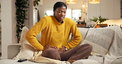 Buy stock photo Stomach ache, couch or black woman with pain in living room, constipation or menstruation cycle for sore belly. Upset, period cramps or person with abdominal problem, digestion trouble or pms in home