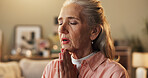 Belief, hope and prayer with senior woman on sofa in living room of home for trust in Christ Jesus. Faith, religion and worship with old person praying to God for confession, forgiveness or guidance