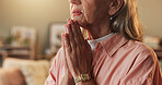 Faith, hands and prayer with senior woman in living room of home for belief, confession or religion. Hope, trust and worship with old Christian person praying to God or Jesus for gratitude and peace