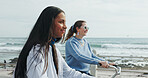 Friends, cycling and women by ocean for travel on summer holiday, vacation and weekend together. Happy, promenade and people with eco friendly transport by sea for bonding, adventure or relax outdoor