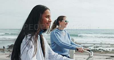 Buy stock photo Friends, cycling and women by ocean for travel on summer holiday, vacation and weekend together. Happy, promenade and people with eco friendly transport by sea for bonding, adventure and ride outdoor