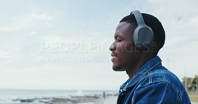 Buy stock photo Travel, man and relax with headphones at ocean for peaceful trip, vacation playlist or mindfulness. Sky space, black person or listening to music at beach with thinking, holiday reflection and audio