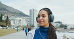 Thinking, tourist and woman with headphones, vacation or listen to music on break, tourism or online. Outdoor, traveller and person with tech for sound, reflection and streaming audio on holiday