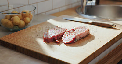 Buy stock photo Cutting board, steak and seasoning in home kitchen for meal preparation, meat dish or dinner recipe. Fresh, food or beef protein with spices on cooking utensils for healthy balanced diet or nutrition