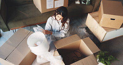 Buy stock photo Woman, unpacking boxes and lamp to new home with real estate investing, mortgage and fresh start. Person, cardboard package and relocation with interior design, above and property purchase at house