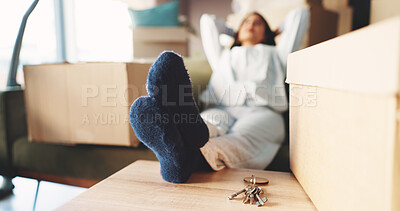 Buy stock photo Feet, new home and tired on sofa, relax and keys with boxes, rest and moving on break in lounge. Person, legs and exhausted on couch with package, relocation or property investment at apartment