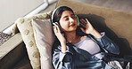 Headphones, relax and above of woman on sofa for audio, podcast and music for calm in home. Eyes closed, living room and person listening to playlist, radio and streaming subscription for wellness