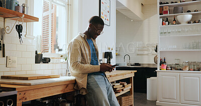 Buy stock photo Cellphone, networking and black man in kitchen in home with communication, connectivity or chatting. Happy, technology and African male person with phone for social media on mobile app in apartment.