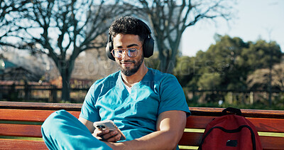 Buy stock photo Man, medical student and headphones with phone for streaming, listening to music and schedule. Male person, intern doctor and mobile for online podcast, radio subscription and healthcare residency