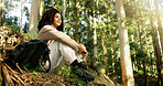 Reflection, sitting or woman with smile in woods for rest, backpacking or recreational hiking for travel. Break, thinking or happy person in forest for nature getaway, ecotourism or scenic holiday