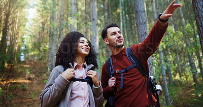 Buy stock photo Couple, hiking and point in forest for direction with search, break and happy with backpack for tourism. Man, woman and interracial relationship with love, smile or sightseeing on trekking adventure