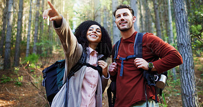Buy stock photo Couple, hiking and point in woods for direction with search, break and happy with backpack for tourism. Man, woman and interracial relationship with love, smile or trekking adventure in forest