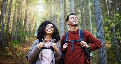Buy stock photo Couple, hiking and sightseeing in woods with smile, reflection or search for location with tourism. Man, woman and interracial relationship with love, happy or trekking adventure on holiday in forest