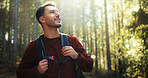 Happy man, hiking and forest with backpack in nature for outdoor adventure in wilderness. Male person, hiker or smile with bag, sunshine or trees for trekking journey, exploration or sightseeing