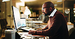 Computer screen, finance and typing with business black man in office at night for investment. Data, display and report with mature portfolio manager at work for evening review of charts or graphs
