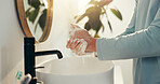 Basin, hygiene and washing hands with person in bathroom of home for morning routine or skincare. Cleaning, protection and soap with man closeup in apartment to remove bacteria, dirt or germs