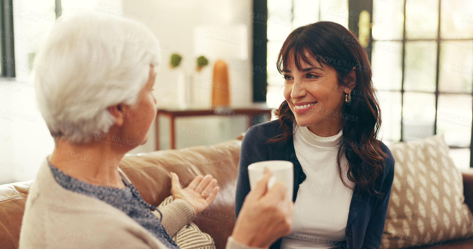 Buy stock photo Bonding, elderly mother and daughter in home with tea, story time and catch up in conversation. Smile, communication and family in house with warm drinks, reunion and gossip in shared moment.