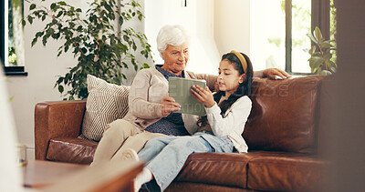 Buy stock photo Home, tablet and grandmother with girl, conversation and bonding together with elearning. Discussion, granny and family on couch, old woman and child development with tech and digital app for ebook
