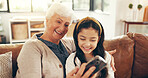 Smile, phone and grandmother with child on sofa in family home for streaming, bonding and movie app. Happiness, film subscription and relax with old woman and kid in living room for love and hug