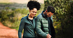 Holding hands, smile and interracial couple hiking in nature for travel, adventure or happy together. Trekking, man and woman outdoor for connection, care and support with partner for love on holiday
