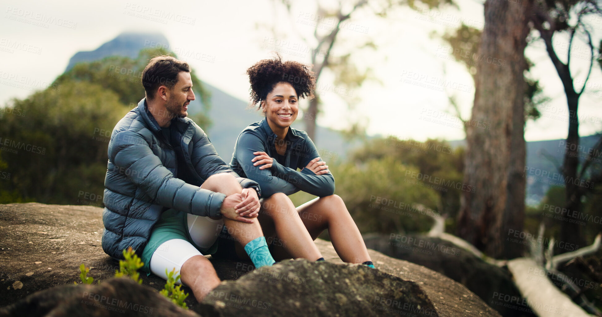 Buy stock photo Happy, couple and relax from hiking in nature with partner, travel adventure and bonding on holiday trip. Smile, people and rest on mountain for sightseeing, trekking break and backpacking vacation 