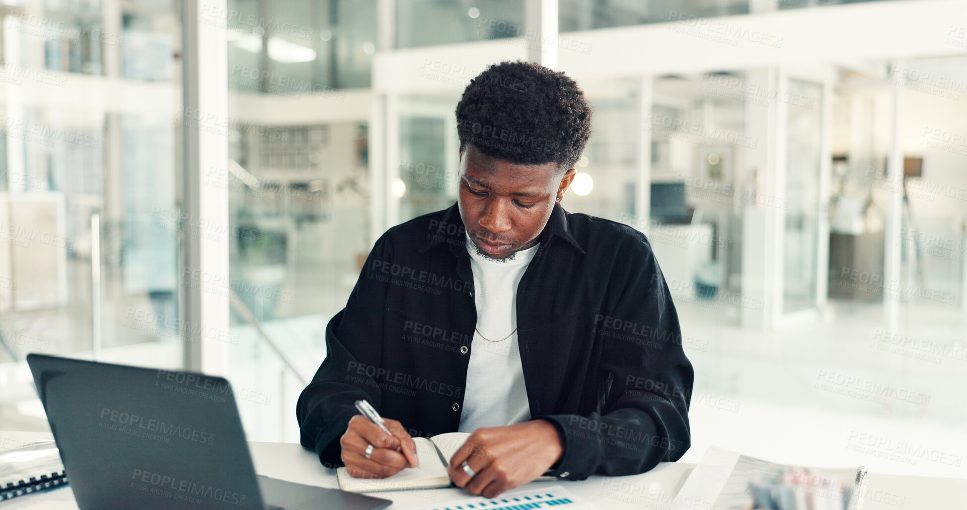 Buy stock photo Black man, business and writing for notes in office with graph paperwork, laptop and creative project at startup. Online insights, research and notebook for schedule, agenda and social media manager