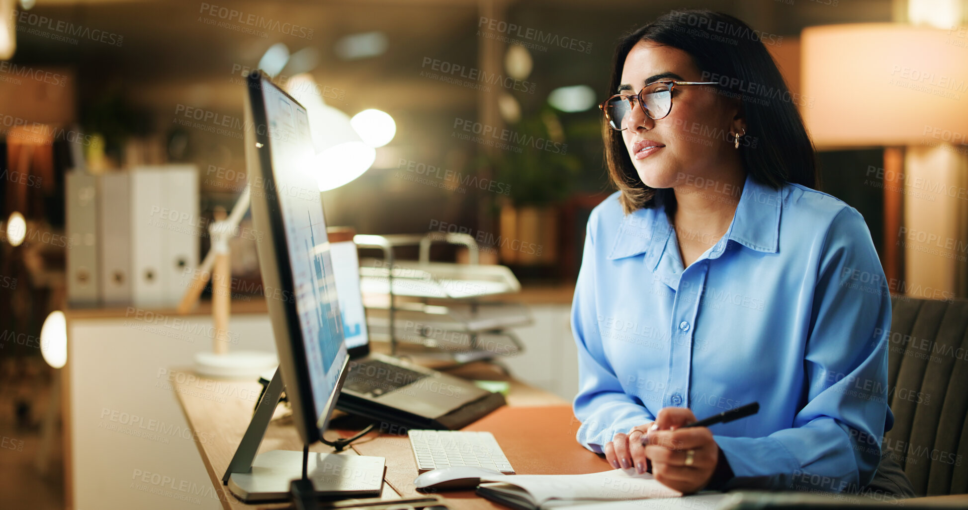 Buy stock photo Writing, night and woman in office with desktop, note taking or problem solve in company analysis. Productivity, graph and data analyst in workplace with tech, solution strategy or info in overtime