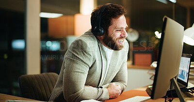 Buy stock photo Night, smile or businessman in office with headphones, comedy podcast or funny video for work break. Overtime, happy or investor with computer in workplace, streaming or watching online for rest
