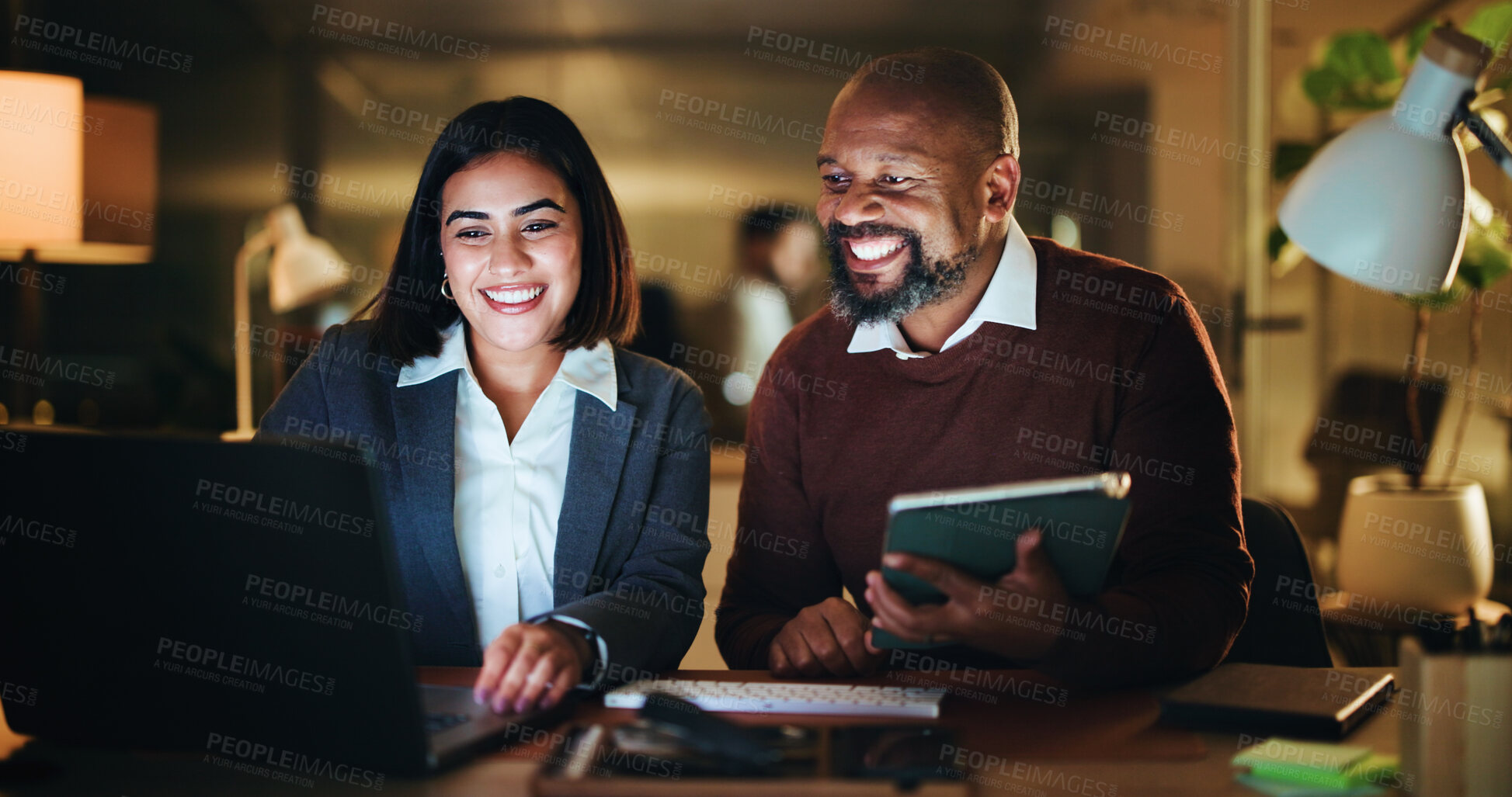 Buy stock photo Night, happy and business people on tech in office for planning, investment decision and finance report. Corporate team, dark and man with woman on laptop for financial review, research or discussion