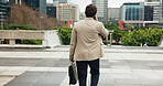 City, commute and phone call with business man from back for travel to job or work location. Buildings, communication and walking with employee person outdoor in urban town for trip to destination