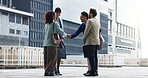 Business people, meeting or handshake with team in city for introduction, greeting or collaboration. Group, employees or colleagues shaking hands with smile for partnership or agreement in urban town