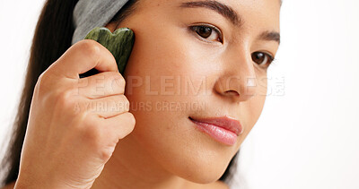 Buy stock photo Skincare, gua sha and woman in studio, beauty and dermatology on white background. Jade crystal, cosmetics or person with wellness, thinking or anti aging with healthy skin treatment with facial care
