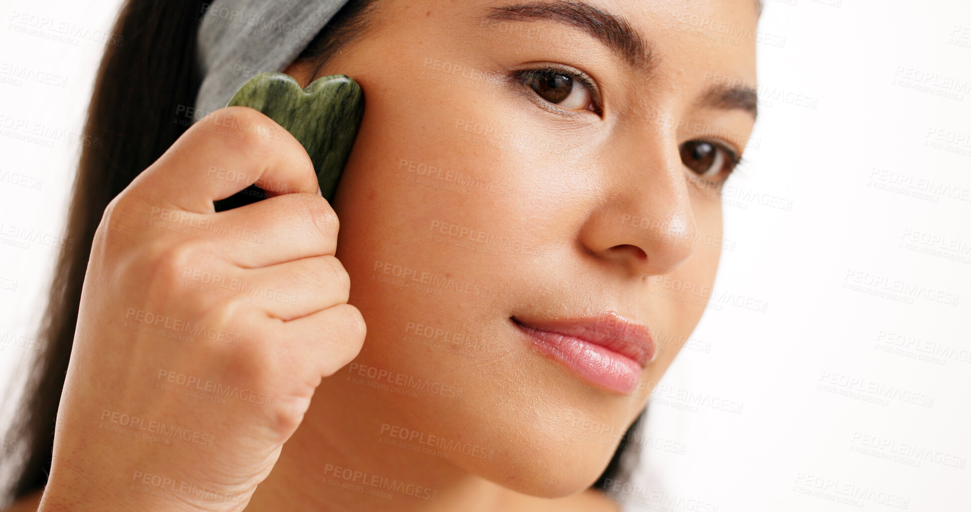 Buy stock photo Skincare, gua sha and woman in studio, beauty and dermatology on white background. Jade crystal, cosmetics or person with wellness, thinking or anti aging with healthy skin treatment with facial care