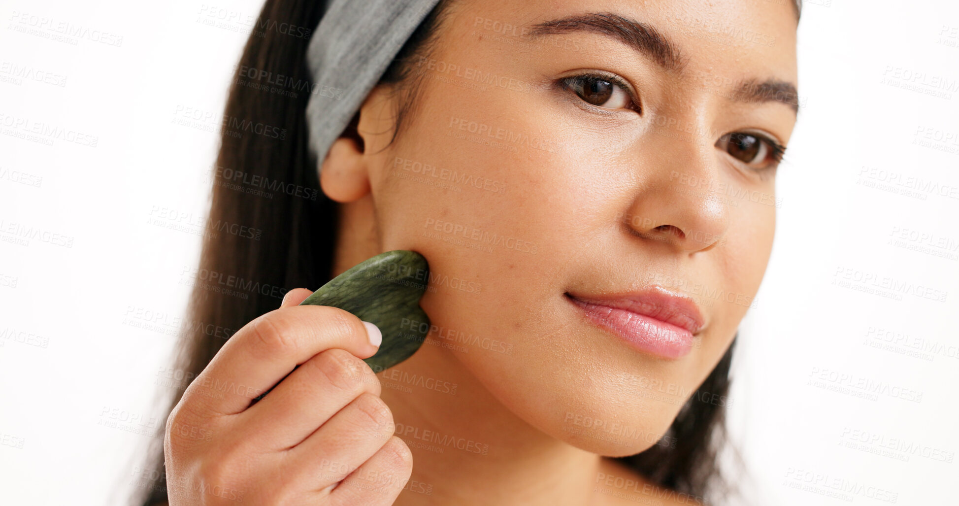 Buy stock photo Cosmetics, gua sha and woman in studio, beauty and dermatology on white background. Jade crystal, skincare or person with wellness, thinking or anti aging with facial care and blood circulation