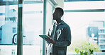 Black man, window and thinking in office with tablet, idea or plan for online campaign. Serious, African person and digital marketing manager in company with tech, reflection and research for ROI.