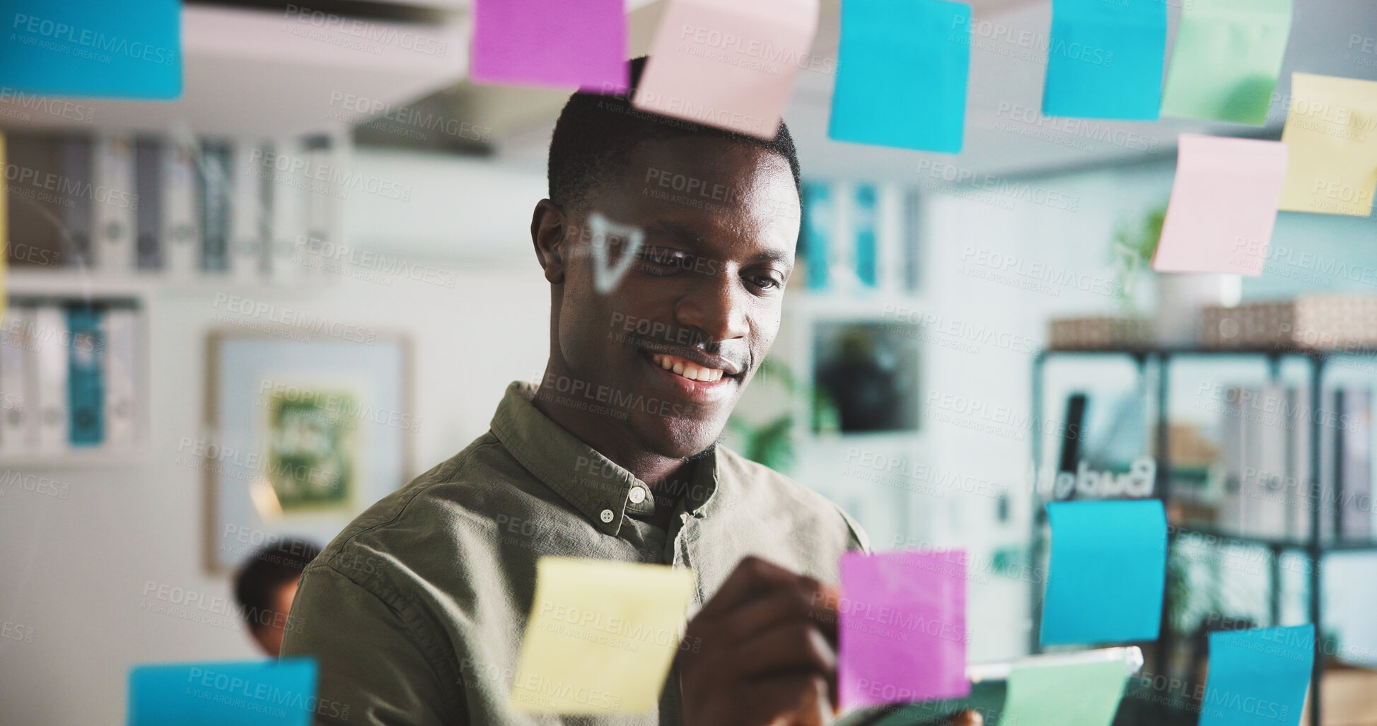 Buy stock photo Happy man, board and sticky note with writing, planning or problem solving for project at media company. Person, glass wall and smile with solution, thinking or perspective at startup creative agency