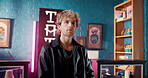 Portrait, serious and man in studio with neon light, startup owner and brand development for artwork. Creative, professionalism and artist in store with signage, culture and promotion for ink design.