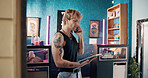 Online booking, phone call and tablet with man in tattoo parlor for artistic or creative appointment. App, conversation and small business with person in studio for body art or ink consultation