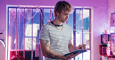 Buy stock photo Drawing, neon and tablet with man in tattoo parlor for artistic design or creative planning. App, pen and small business with designer person in studio for ink or process of body art development